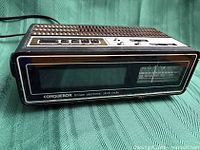 Front view showing Conqueror branding, digital display and radio dial