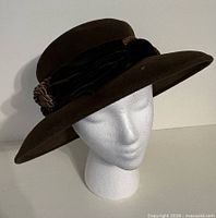Front view of brown felt cloche hat on mannequin