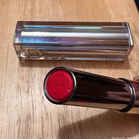 Lipstick bullet extended with silver case alongside
