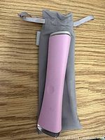 Pink Foreo Espada device resting on gray drawstring pouch