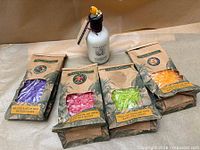 Group shot of four bath salt packs with visible contents and one body milk lotion bottle