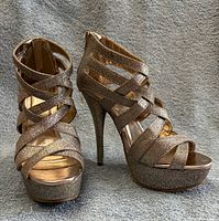 Front three-quarter view of both glitter strappy stilettos