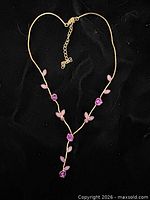 Full view of necklace showing Y shape, floral motif, extender chain