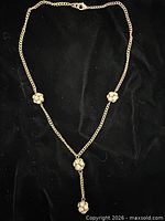 Full view of gold-tone Y-necklace on black background