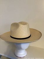 Front view of straw hat on stand