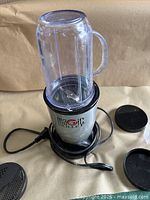 Blender base with cup attached showing cord and lid