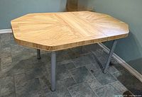 Dining table without leaf, showing octagonal-corner top and metal legs