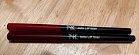 Two Nicka K auto lip liners lying side by side showing exterior