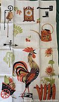 Full view of one towel showing rooster and farm imagery