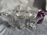 Six clear glass sundae cups grouped together