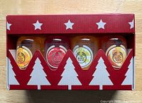 Front of sealed gift box showing four bottles and holiday graphics