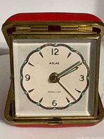 Front view of Atlas travel alarm clock, dial visible