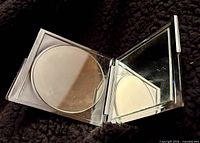 compact opened showing standard and magnifying mirrors