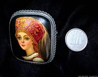 Front view showing painted portrait and size reference with Canadian dime