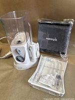 Overall lot showing water flosser base, reservoir, tip tray, travel case