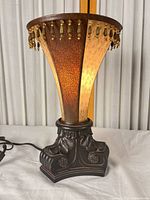 Full view of lamp showing shade, beaded fringe, and base