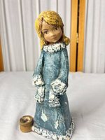 Full view of Borzo girl figurine showing attached candle cup and overall wear