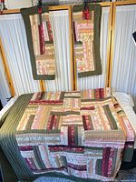 Quilt spread on bed with two shams clipped above