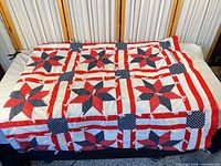 Full view of quilt laid on bed showing star-and-stripe pattern and size coverage