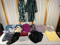 overview of all clothing and accessories laid out and three garments hanging