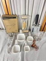 Full lot showing boxed jar opener, roller, bench scraper, whisk, measuring cups, spoons, clear cups