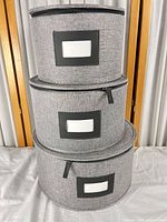 Three gray round fabric storage boxes stacked