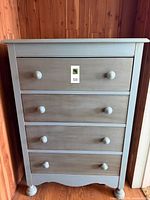 Front view of two-tone four-drawer dresser showing paint colours, knobs, and base design