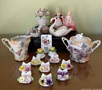 Group shot of entire lot displaying sugar & creamer, 8 place-card holders, Denton shakers, Aynsley figurine, Herend box, Lenox swan, Royal Doulton figurines, I.W. Rice lamp