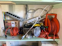 Shelf with cords, power strips, reel