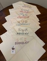 All six embroidered weekday towels displayed in sequence