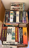 Overview of two boxes showing Time-Life WWII hardcovers and misc titles stacked