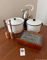 group shot of all six kitchen items: two enamel pots, two mashers, wooden cheese grater, copper kettle