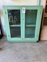 Front view of green glass-front cabinet