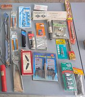 Overview of all packaged and loose hand tools and fasteners on table surface
