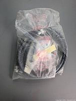 Hose assembly in sealed plastic bag showing overall shape and fittings