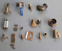 Overview of all brass plumbing fittings and hardware pieces laid out on surface