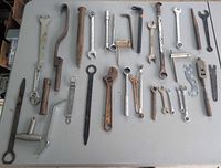 Entire lot laid out on table displaying wrenches, sockets, pry bars, chisels, punches, hex keys