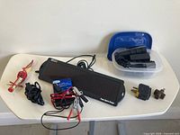 Lot overview showing solar panel, controller, battery chargers, plugs and cables
