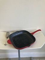 Square red enameled cast iron grill pan with handheld frother