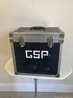 Front view of black hard shell road case showing GSP stencil and latches