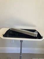 Black 1U rack shelf with smaller tray and wrapped rack ears on tabletop