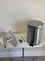 Group shot showing trash bin, exhaust hose, level, pedometer, tin