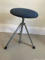 Drum stool assembled showing denim seat, chrome tripod legs, rubber feet