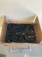 box filled with coiled black RCA cables