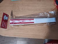 Folded red and white item labelled Hand Fan (seller states headband) in original plastic