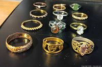 All twelve rings arranged on black surface