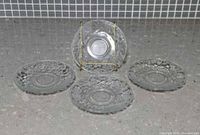 Full lot showing four clear embossed grape pattern plates, one displayed upright