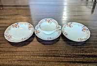 Teacup centered between three saucers showing full set