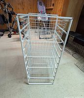 Full view of white wire storage tower showing frame and five baskets