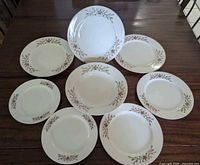 Full set of eight floral plates and bowl displayed
